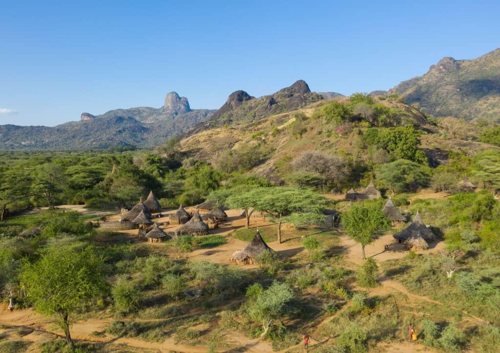 Homes and fields beneath rocky hills